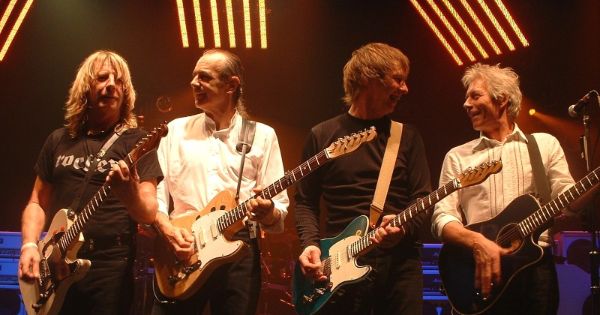 Image in QuizMyDay Status Quo Quiz: Test Your Rock Music Knowledge trivia quiz featuring Status Quo on stage at the Colston Hall in Bristol on 15th November 2005 (L to R: Rick Parfitt, Francis Rossi, John 'Rhino' Edwards and Andrew Bown).