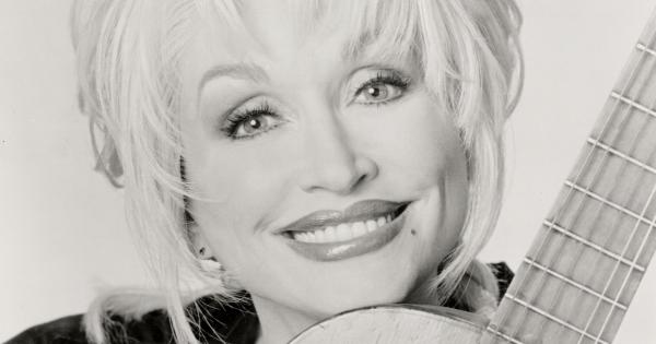 Image in QuizMyDay Dolly Parton trivia fun quiz featuring Dolly Parton with a guitar.