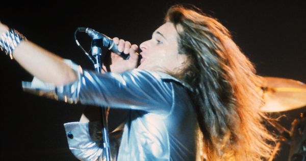 Image in QuizMyDay David Lee Roth Trivia: Van Halen Era Deep Dive trivia quiz featuring David Lee Roth, singer of Van Halen, performing live in 1978.