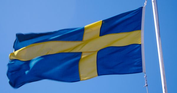 Image in QuizMyDay Ultimate Swedish Bands Trivia: Test Your Knowledge trivia quiz featuring The Swedish flag blowing in the wind.