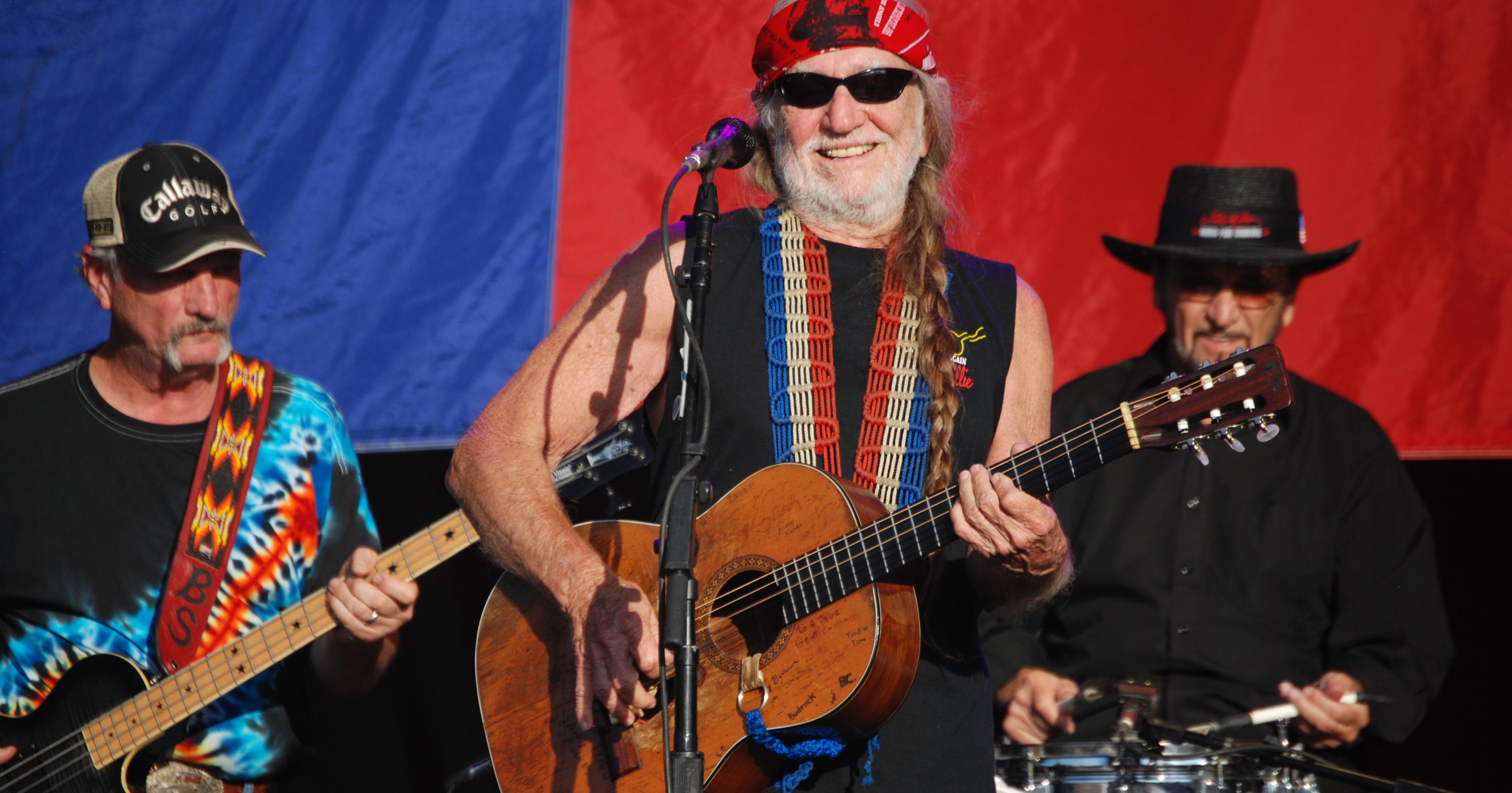 An image in QuizMyDay Willie Nelson trivia quiz featuring Willie Nelson in concert at Stockton's Banner Island Park. 