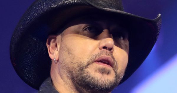 Image in QuizMyDay Jason Aldean Country Facts Showdown Quiz trivia quiz featuring Jason Aldean and Brittany Aldean speaking with attendees at the 2022 AmericaFest at the Phoenix Convention Center in Phoenix, Arizona.