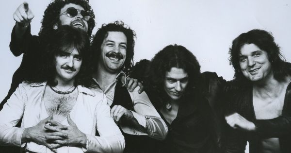 Image in QuizMyDay Obscure Classic Rock Songs Quiz Challenge trivia quiz featuring Publicity photo of the band <a href="https://en.wikipedia.org/wiki/Blue_%C3%96yster_Cult" class="extiw" title="en:Blue Öyster Cult">Blue Öyster Cult</a> issued by <a href="https://en.wikipedia.org/wiki/Columbia_Records" class="extiw" title="en:Columbia Records">Columbia Records</a> in 1977 of the lineup that lasted from 1971 to 1981. Left to right: Donald "Buck Dharma" Roeser (white shirt); behind him Eric Bloom (sunglasses); Albert Bouchard; Allen Lanier; Joe Bouchard