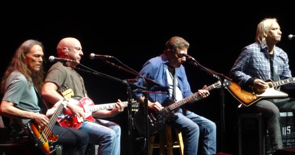 Image in QuizMyDay The Eagles Quiz: Ultimate Band Trivia trivia quiz featuring The Eagles in concert, "History of the Eagles" tour, Grand Rapids, September 2014. Doolin-Dalton.  Left to right - Timothy B. Schmit, Bernie Leadon, Glenn Frey, Joe Walsh.  Don Henley on drums singing lead vocals not shown