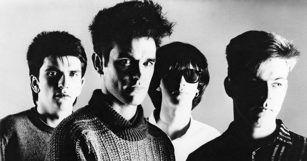 Image in QuizMyDay Make Waves: Name That New Wave Band Quiz Challenge trivia quiz featuring The Smiths in a promotional photo for their self titled debut album <i>The Smiths</i>, circa 1984. From left to right; <a href="https://en.wikipedia.org/wiki/Mike_Joyce_(musician)" class="extiw" title="w:Mike Joyce (musician)">Mike Joyce</a>, <a href="https://en.wikipedia.org/wiki/Morrissey" class="extiw" title="w:Morrissey">Morrissey</a>, <a href="https://en.wikipedia.org/wiki/Johnny_Marr" class="extiw" title="w:Johnny Marr">Johnny Marr</a>, and <a href="https://en.wikipedia.org/wiki/Andy_Rourke" class="extiw" title="w:Andy Rourke">Andy Rourke</a>.