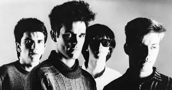 Image in QuizMyDay The Smiths Songs Quiz – Test Your Music Trivia Skills trivia quiz featuring The Smiths in a promotional photo for their self titled debut album <i>The Smiths</i>, circa 1984. From left to right; <a href="https://en.wikipedia.org/wiki/Mike_Joyce_(musician)" class="extiw" title="w:Mike Joyce (musician)">Mike Joyce</a>, <a href="https://en.wikipedia.org/wiki/Morrissey" class="extiw" title="w:Morrissey">Morrissey</a>, <a href="https://en.wikipedia.org/wiki/Johnny_Marr" class="extiw" title="w:Johnny Marr">Johnny Marr</a>, and <a href="https://en.wikipedia.org/wiki/Andy_Rourke" class="extiw" title="w:Andy Rourke">Andy Rourke</a>.
