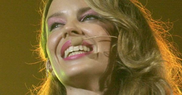 Image in QuizMyDay Ultimate Kylie Minogue Songs Quiz: Can You Name the Hit from the First Note? trivia quiz featuring Australian singer Kylie Minogue performing infront of the Paralympic Flame during the Sydney Paralympic Games Opening Ceremony
