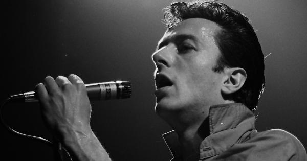 Image in QuizMyDay Ultimate The Clash Quiz: Punk Rock Showdown Now trivia quiz featuring Joe Strummer performing with the Clash at the Tower Theater