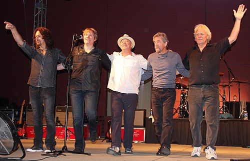 The five members of Creedence Clearwater Revisited on an outdoor stage at the Mayo Civic Center in Rochester, Minnesota, United States