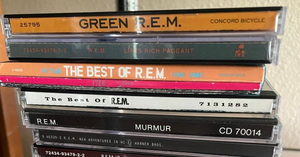 Image in QuizMyDay R.E.M. Discography Quiz: Test Your Album Knowledge trivia quiz featuring R.E.M. albums (from top to bottom): <i>Green</i>, <i>Lifes Rich Pageant</i>, <i>In Time: The Best of R.E.M.</i>, <i>The Best of R.E.M.</i>, <i>Murmur</i>, <i>New Adventures in Hi-Fi</i>, <i>Fables of the Reconstruction</i>/<i>Reconstruction of the Fables</i>, <i>R.E.M. in the Attic</i>, <i>Monster</i>, <i>Document</i>, <i>Automatic for the People</i>, and <i>Up</i>.