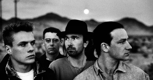 Image in QuizMyDay U2 Members Quiz: Test Your Knowledge of the Band Members and Albums trivia quiz featuring Irish band U2, in a 1987 publicity photo promoting its album <a href="https://en.wikipedia.org/wiki/The_Joshua_Tree" class="extiw" title="w:The Joshua Tree"><i>The Joshua Tree</i></a>, part of the photoshoot made by <a href="https://en.wikipedia.org/wiki/Anton_Corbijn" class="extiw" title="w:Anton Corbijn">Anton Corbijn</a>. From left to right: <a href="https://en.wikipedia.org/wiki/Larry_Mullen_Jr." class="extiw" title="w:Larry Mullen Jr.">Larry Mullen</a>, <a href="https://en.wikipedia.org/wiki/Adam_Clayton" class="extiw" title="w:Adam Clayton">Adam Clayton</a>, <a href="https://en.wikipedia.org/wiki/The_Edge" class="extiw" title="w:The Edge">The Edge</a>, <a href="https://en.wikipedia.org/wiki/Bono" class="extiw" title="w:Bono">Bono</a>.