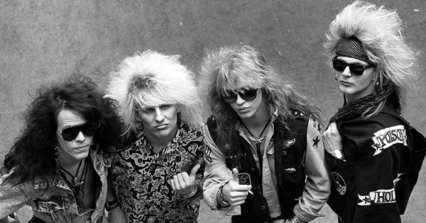 Four members of rock band Poison: Bobby Dall, C.C. DeVille, Bret Michaels, and Rikki Rockett posed together.