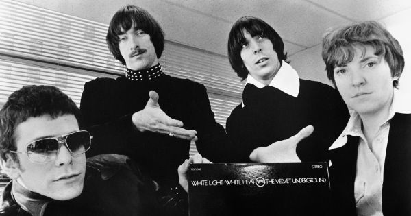 Image in QuizMyDay Velvet Underground Trivia Quiz: 5 Questions of Lore trivia quiz featuring A publicity photo of the American rock band <a href="https://en.wikipedia.org/wiki/The_Velvet_Underground" class="extiw" title="w:The Velvet Underground">The Velvet Underground</a> circa 1968, promoting their second album <i><a href="https://en.wikipedia.org/wiki/White_Light/White_Heat" class="extiw" title="w:White Light/White Heat">White Light/White Heat</a></i>. The band members are positioned around a copy of the album, with the text of the title visible against a black background. From left to right: <a href="https://en.wikipedia.org/wiki/Lou_Reed" class="extiw" title="w:Lou Reed">Lou Reed</a>, <a href="https://en.wikipedia.org/wiki/Sterling_Morrison" class="extiw" title="w:Sterling Morrison">Sterling Morrison</a>, <a href="https://en.wikipedia.org/wiki/John_Cale" class="extiw" title="w:John Cale">John Cale</a>, and <a href="https://en.wikipedia.org/wiki/Maureen_Tucker" class="extiw" title="w:Maureen Tucker">Maureen Tucker</a>.