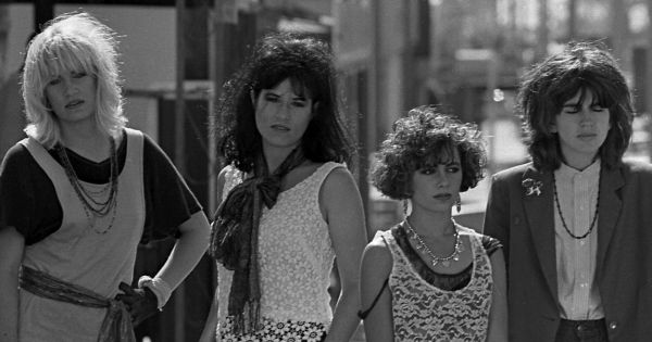 Image in QuizMyDay Ultimate Bangles Trivia Quiz: Test Your Fandom trivia quiz featuring Los Angeles based music group, The Bangles, posing on street in Los Angeles. From left, Debbi Peterson, Vicki Peterson, Susanna Hoffs and Michael Steele