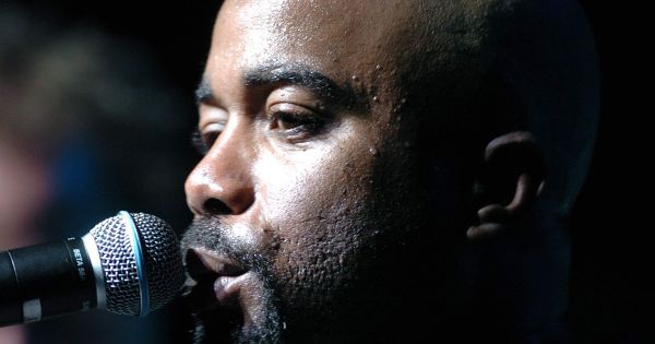 Image in QuizMyDay Darius Rucker Quiz: Test Your Country Music Expertise trivia quiz featuring Darius Rucker, lead singer of Hootie and the Blowfish, sings to a crowd during an Operation Pacific Greetings tour concert