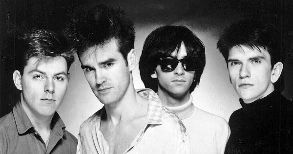Image in QuizMyDay The Smiths Albums Quiz: Test Your Music Expertise trivia quiz featuring The Smiths in a promotional photograph for their debut album <i>The Smiths</i>, circa 1984. From left to right; <a href="https://en.wikipedia.org/wiki/Andy_Rourke" class="extiw" title="w:Andy Rourke">Andy Rourke</a>, <a href="https://en.wikipedia.org/wiki/Morrissey" class="extiw" title="w:Morrissey">Morrissey</a>, <a href="https://en.wikipedia.org/wiki/Johnny_Marr" class="extiw" title="w:Johnny Marr">Johnny Marr</a>, and <a href="https://en.wikipedia.org/wiki/Mike_Joyce_(musician)" class="extiw" title="w:Mike Joyce (musician)">Mike Joyce</a>. This photo was also issued later to promote their 1985 album <i>Meat Is Murder</i>.