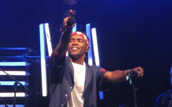 Frank Ocean holds out his microphone to the crowd while performing at Coachella 2012.