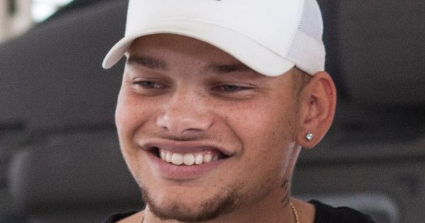 Image in QuizMyDay Kane Brown Quiz Challenge: Can You Score 5/5? trivia quiz featuring Country music singer Kane Brown takes a photo with a California Army National Guard soldier, Sept. 7, 2018, in a UH-60 Black Hawk hangar at Joint Forces Training Base, Los Alamitos, California. Brown filmed the video for his new song, "Homesick," in the hangar earlier in the morning. (U.S. Air National Guard photo by Senior Airman Crystal Housman)