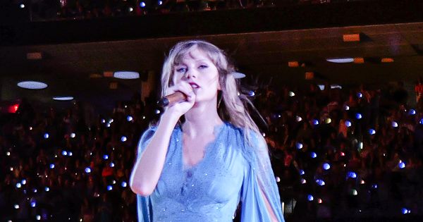 Image in QuizMyDay Test Your Taylor Swift IQ: Life of a Showgirl Quiz trivia quiz featuring Taylor Swift performing the Folklore act in a blue dress